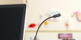 A headset sitting on a desk with a computer in an office representing a business exploring the best contact center software.